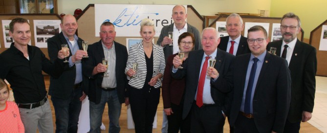 Bürgermeister Nils Anhuth stößt mit dem Aktivkreis Harkebrügge auf das Jubiläum an.