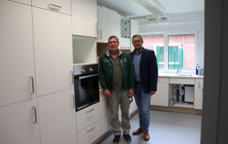 Gemeindejugendpfleger Hartmut Börcher (links) besichtigt mit BM Nils Anhuth die neue Küche im JuBZ.
