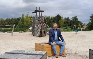 Bürgermeister Nils Anhuth testet die neuen Sitzgelegenheiten auf dem Traumspielpark.