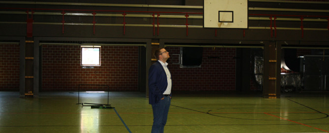 Bürgermeister Nils Anhuth in der Sporthalle VOR der Sanierung.