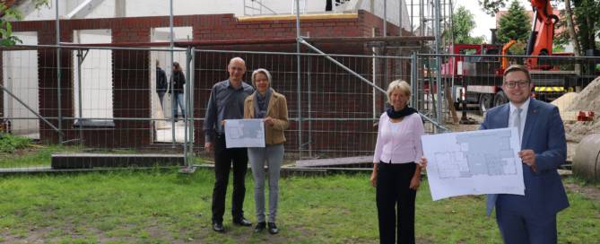 Sie freuen, sich dass der Dachstuhl im Hintergrund errichtet wird (v.l.n.r.): Thomas und Wiebke Perzul, Heike Pieper und BM Nils Anhuth. Aufnahme: Wlodarczyk/Gemeinde Barßel